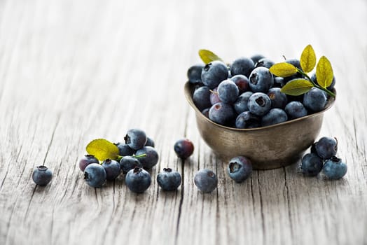 Fresh blueberries with leaf in a bowl close up. Concept for healthy eating and nutrition
