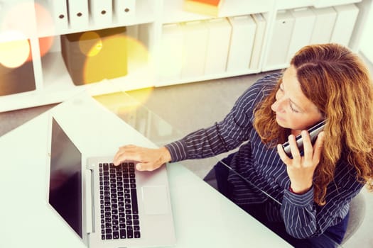 brown-haired businesswoman working with computer and calling in the office