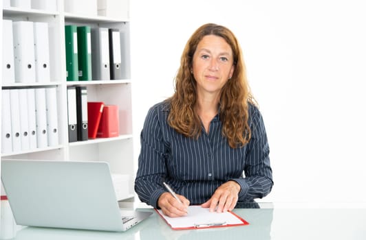 brown-haired  businesswoman working and writing  in the office