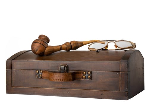 Old wooden chest with tobacco pipe and a pair of glasses on it isolated on white background.