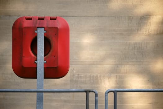 Emergency equipment with a lifebuoy on the railing and the outer wall of a weir.