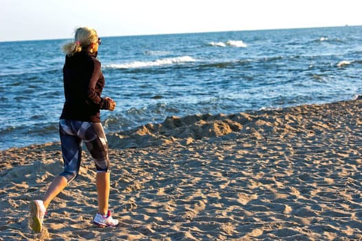 young beautiful sportswoman doing exercises on beach