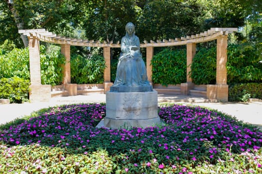 Seville, Spain - July 7th, 2018: Statue of the princess Luisa Fernanda by Enrique Perez Comendador. The park bearing her name.