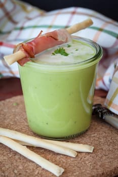 Homemade creamy pea soup and bread sticks with smoked ham