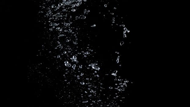 Close-up images of soda water splashing in the water to many little bubbles that make it feel like refreshing and black background