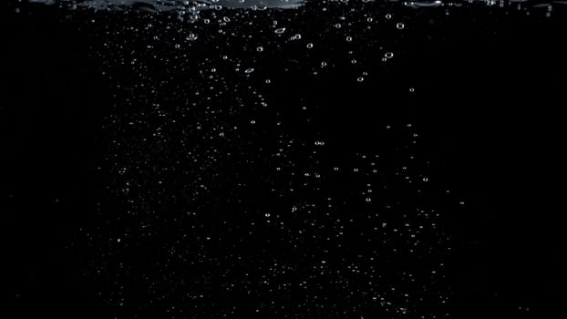 Close-up images of soda water splashing in the water to many little bubbles that make it feel like refreshing and black background