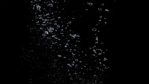 Close-up images of soda water splashing in the water to many little bubbles that make it feel like refreshing and black background