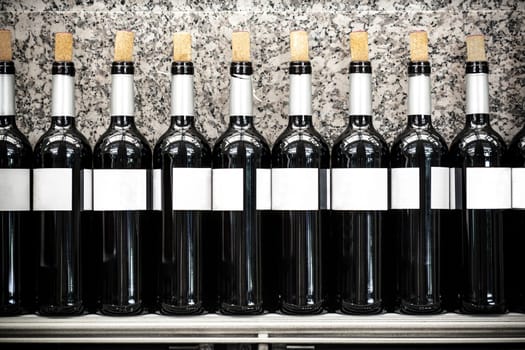 Restaurant shelf full of opened wine red spanish bottles