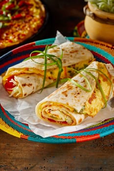 Traditional indigenous Ugandan Rolex Rolls, a popular street food made with chapati, egg omelette and fresh vegetables served on a colourful basket