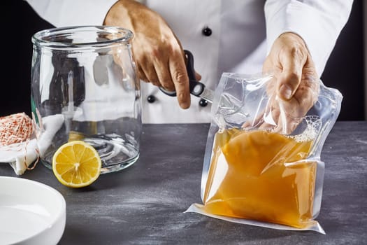 Man opening bag with symbiotic culture of bacteria and yeast to prepare kombucha tea