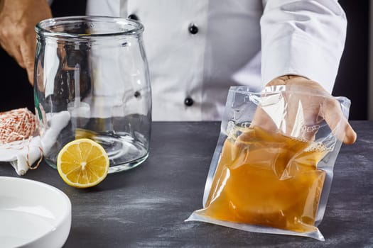 Man holding plastic bag with symbiotic culture of bacteria and yeast to prepare kombucha tea