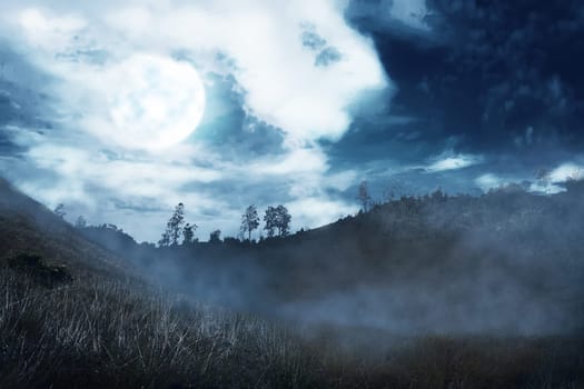 Misty hill with dark cloud and full moon on the night. Halloween background