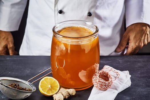 Scoby and starter liquid placed in the sweetened black tea in a sterilised glass jar to begin the fermentation process to produce kombucha