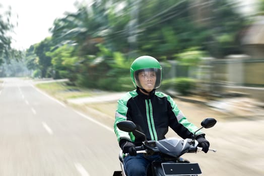 Young man working as motorcycle taxi driver on the urban street