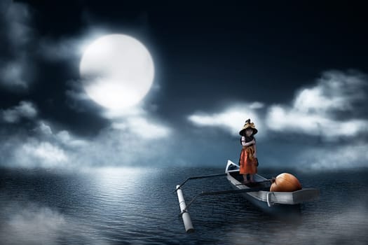 Portrait of asian little girl with witch costume and pumpkin on the boat in lake at night