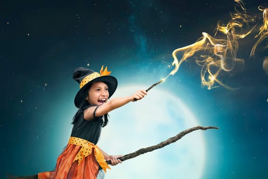 Beautiful asian witch girl using the magic wand with night background