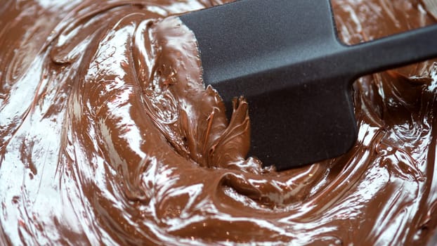 Close-up images of chocolate bar top view angle and cocoa seed with bowl of dark brown cream milk swirling by handmade for represent one of delicious sweet in the World