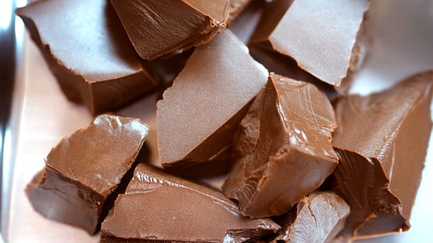 Close-up images of chocolate bar top view angle and cocoa seed with bowl of dark brown cream milk swirling by handmade for represent one of delicious sweet in the World