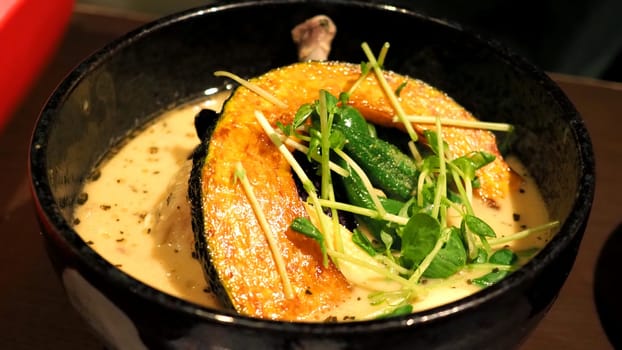 Close-up images of yellow color soup curry with chicken, pork and vegetable in bowl which famous traditional food menu and only found in Hokkaido Sapporo district of Japan