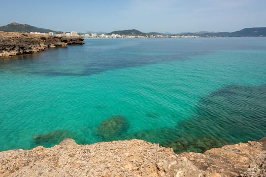 View over the clear turquoise waters of the Mediterranean to the beach of Cala Millor on the Spanish Mediterranean island Mallocra