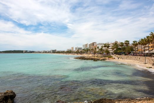 View over the turquoise Mediterranean to the big beach of Cala Millor with its promenade and the many hotels on the Spanish holiday island Mallorca