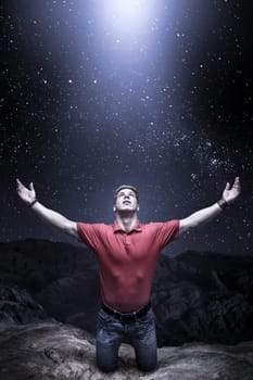 Young man knelt before a light from the sky