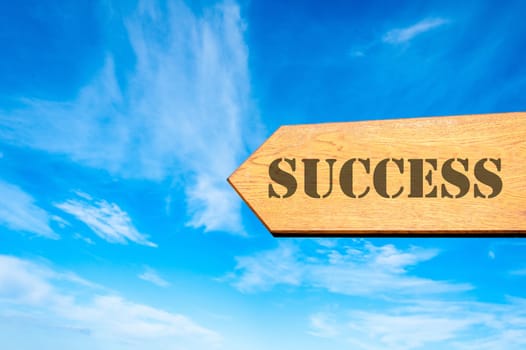 Wood arrow sign against clear blue sky with with Success message, Success conceptual image