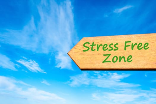 Wood arrow sign against clear blue sky with Stress Free zone message