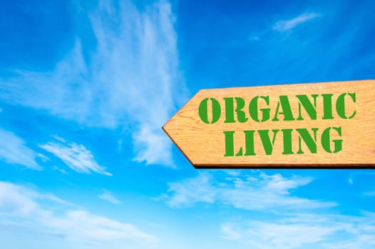 Wood arrow sign against clear blue sky with Organic Living message, Healthy Living concept