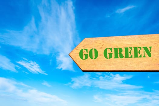 Wood arrow sign against clear blue sky with Go Green message, Eco concept