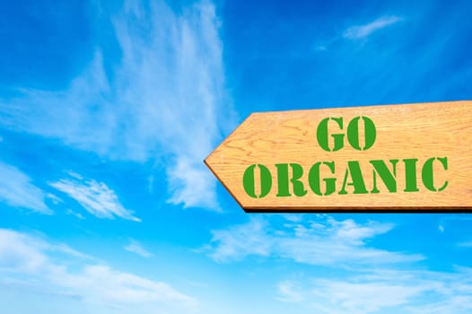 Wood arrow sign against clear blue sky with Go Organic message, Healthy Lifestyle concept