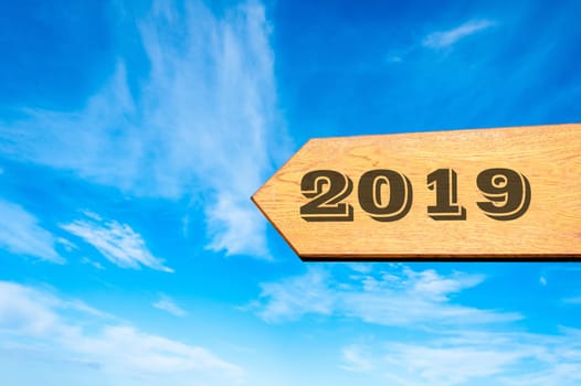 Wood arrow sign against clear blue sky with year 2019 text, Happy New Year conceptual image