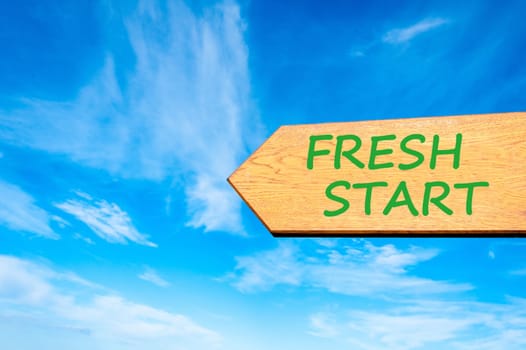 Wood arrow sign against clear blue sky with Fresh Start, Life change conceptual image