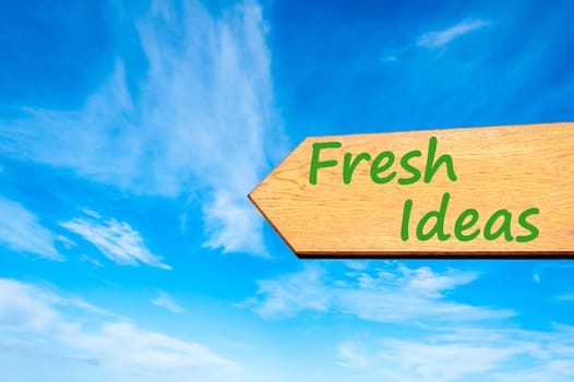 Wood arrow sign against clear blue sky with Fresh Ideas message