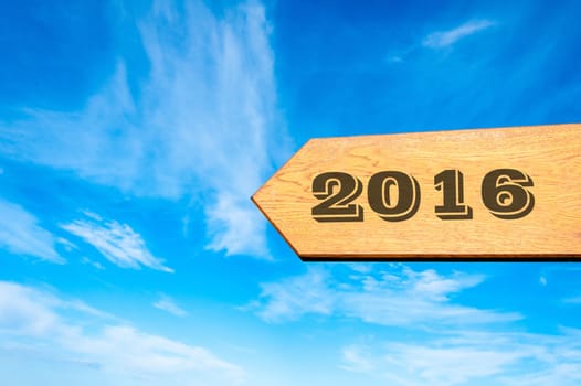 Wood arrow sign against clear blue sky with year 2016 text, Happy New Year conceptual image