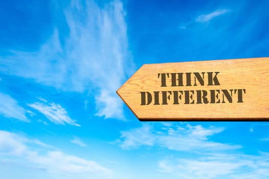 Wood arrow sign against clear blue sky with Think Different message, Business Vision concept