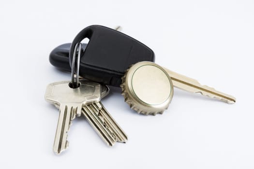car key and bottle cap in close up with neutral grey background