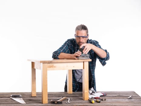 worker in blue plaid shirt repair a table