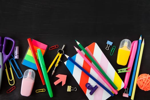 Colorful office / school supplies on a black background