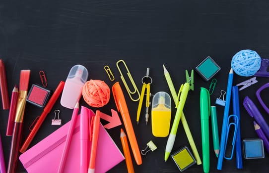 Colorful office / school supplies on a black background