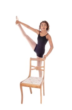 A lovely young woman in a ballet outfit praxis some movements for.her ballet dancing, isolated for white background.