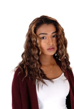 A closeup image of a very serious looking teenager with long curly.brunette hair, looking into camera, isolated for white background.