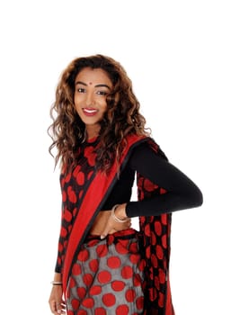 A happy young Indian girl standing in a traditional Indian saree, smiling .with one hand on her hip, isolated for white background.