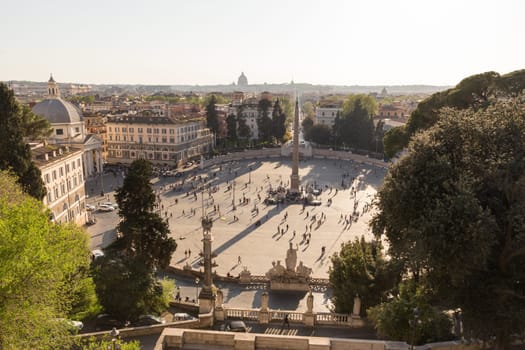 Aerial view of people, sculptures, fountain and churches on Piazza del Popolo in Rome, Italy. Landmarks of eternal city of Rome.
