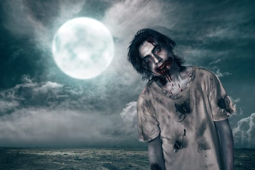 Creepy zombie man with blood on his mouth over moonlight background
