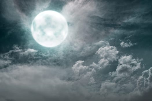 Dramatic view of full moon with dark clouds on the sky