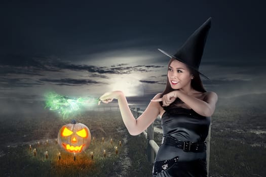Pretty asian witch woman show her magic wand power on the midnight