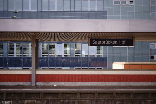 A platform from the main station in Saarbruecken with modern architecture in the background.