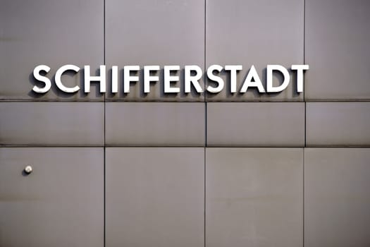 The name plate of the city Schifferstadt on the sheet metal facade of a station building.