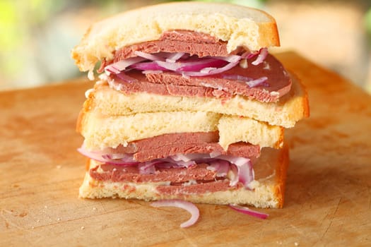 Stacked sandwich halves with braunschweiger, red onions and mayonnaise on buttermilk bread